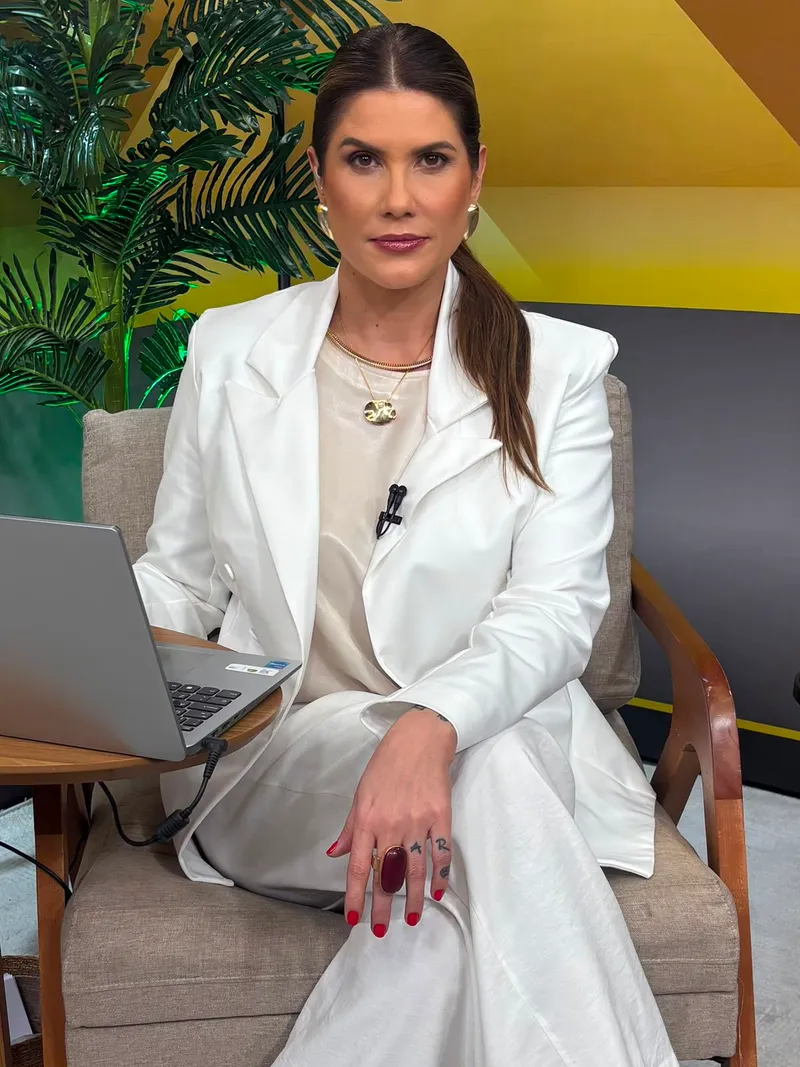 Adriana Reid no estúdio, sentada com notebook