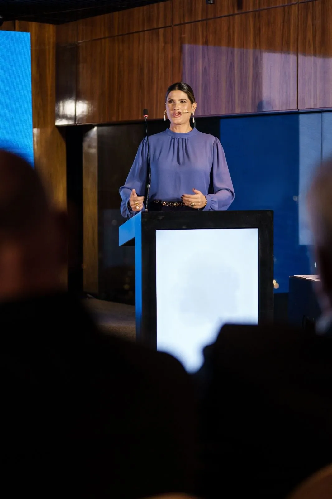 Adriana Reid apresentando em palco, com microfone de lapela